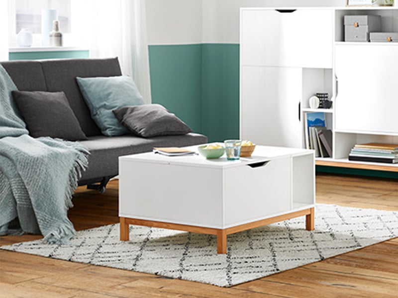 Weißer Couchtisch mit Holz-Füßen im skandinavischen Wohnstil