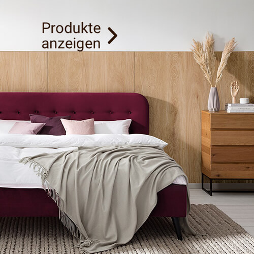 Gemütliches rotes Bett mit hellen Bezügen