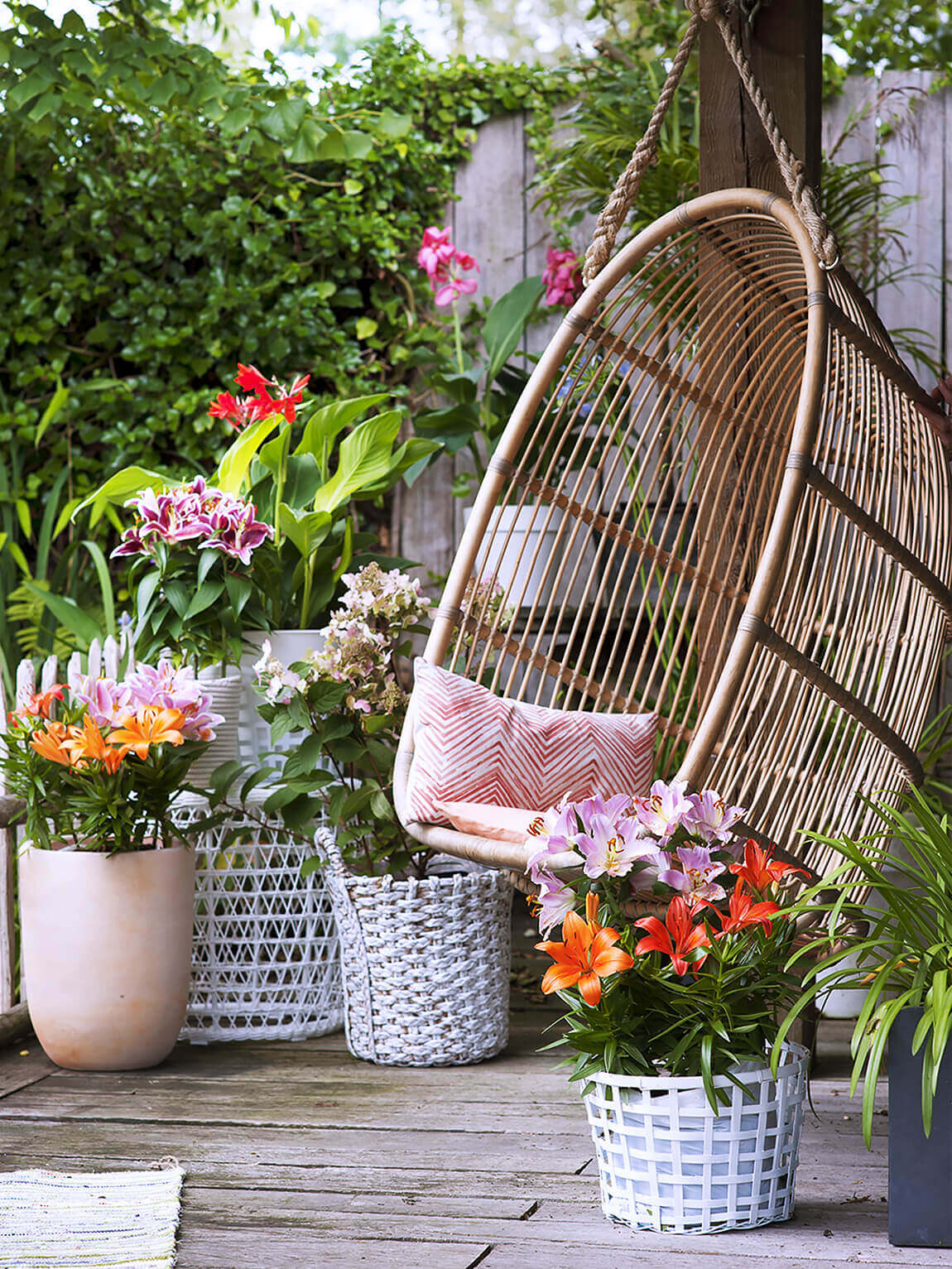 Hängesessel aus Rattan mit vielen bunten Blumen