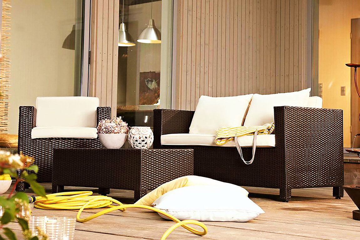 Loungemöbel aus Rattan mit hellen Kissen