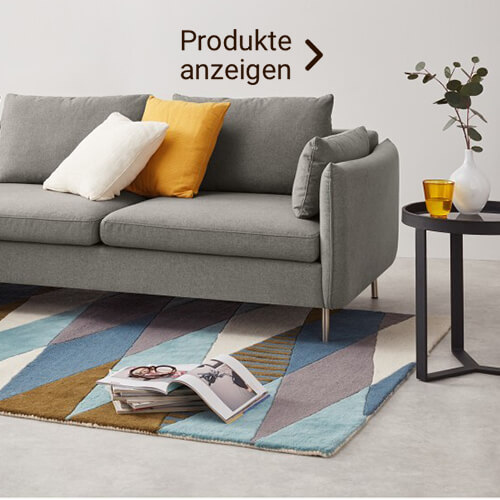 Graue Couch im Skandi Stil mit bunten Kissen 